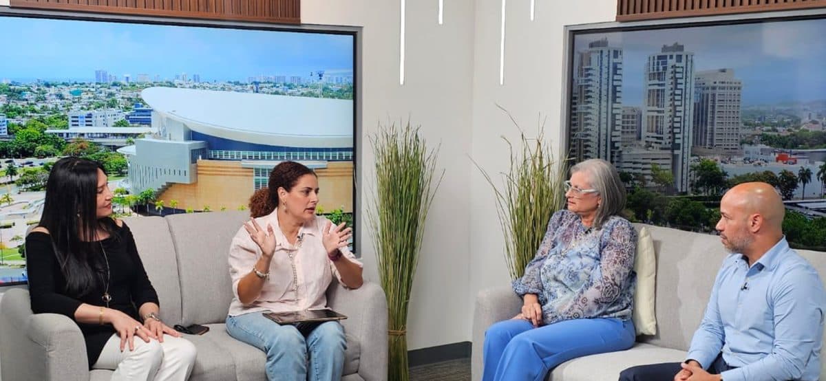 Michelle De La Cruz sentada con tres participantes en el set del podcast del Colegio de CPA.